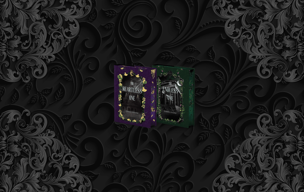 OwlCrate limited editions of The Heartless One and The Endless One book set. The front covers of two books are centered on a black patterned background with silver filigree designs framing the corners.