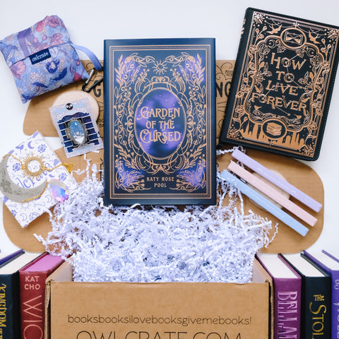A purple fantasy themed Owlcrate subscription box with an array of books and accessories