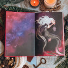 Opening endpaper of The Dark is Descending by Chloe C Peñaranda showing two people kissing, a woman with long flowing white hair and a dark-haired elven man, floating in space.